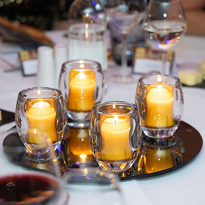 Stilvoll beleuchteter Festtisch mit Bolsius Relight Kerzen in hochwertigen Glashaltern. Die wiederbefüllbaren Relight-Systeme sorgen für stimmungsvolles Licht und sind ideal für Gastronomie und Events.