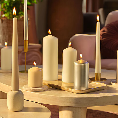 Arrangement mit brennenden Stumpenkerzen und Tafelkerzen von Bolsius – die Stumpenkerzen in verschiedenen Größen und Farben verbreiten warmes, ruhiges Kerzenlicht und sorgen für eine gemütliche Wohnatmosphäre.