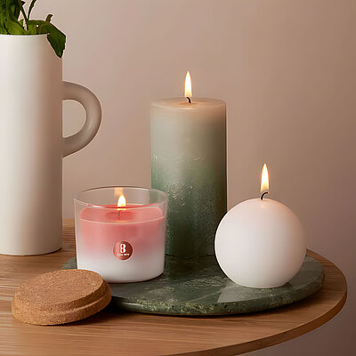 Elegante Szene mit brennenden Kugelkerzen in Weiß, flankiert von Duftstäbchen und Stumpenkerze – stilvolle Deko mit warmem, weichem Licht.